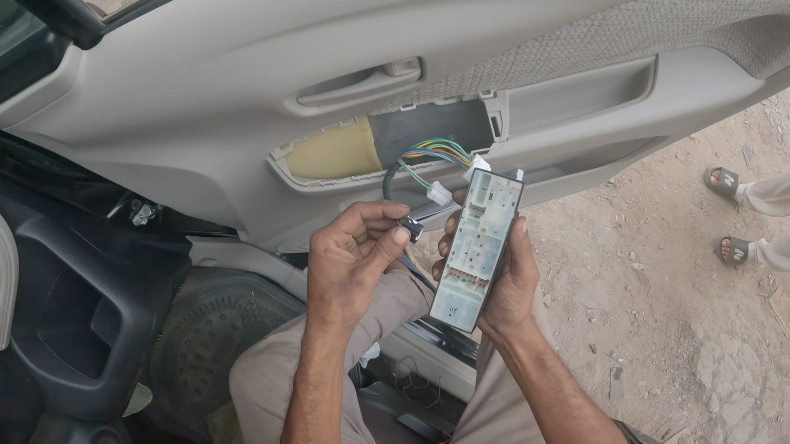 First-person view of hands connecting a vehicle door wiring module